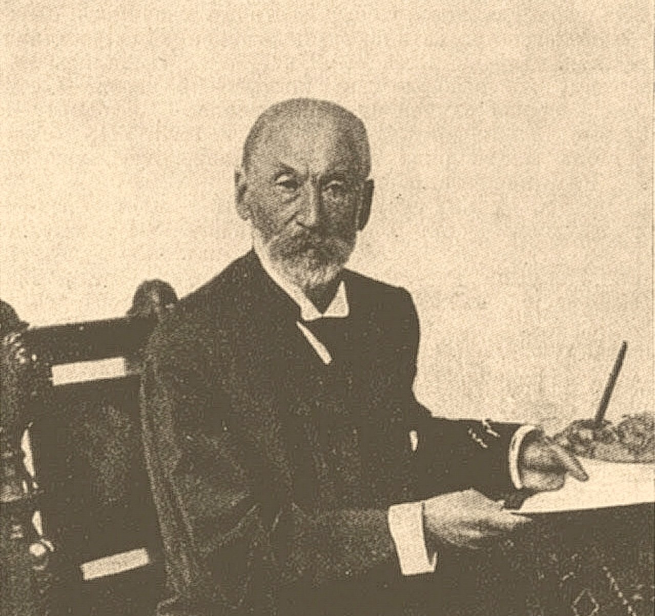 A grainy sepia-toned image of Salomon Rubin sitting at a desk holding a pen, from Brockhaus and Efron Jewish Encyclopedia, 1906-1913