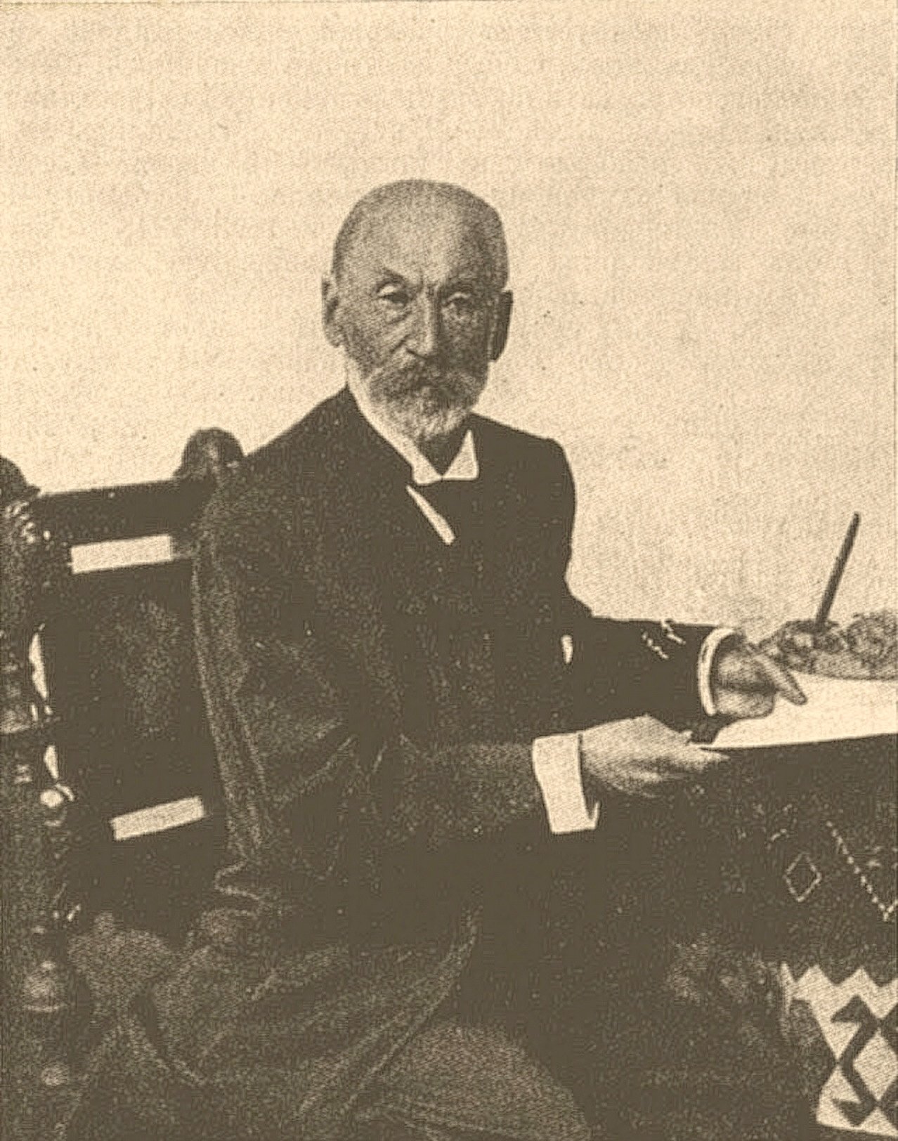 A grainy sepia-toned image of Salomon Rubin sitting at a desk holding a pen, from Brockhaus and Efron Jewish Encyclopedia, 1906-1913